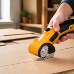 Cordless electric scissors cutting a flattened cardboard box