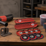 Cut-off wheels, grinding wheels and flap discs arranged beside an angle grinder