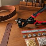 Leather hole punch and grommet tool kit on a home leathercraft workbench