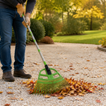 Homeowner raking dry autumn leaves from a gravel path without moving the rocks