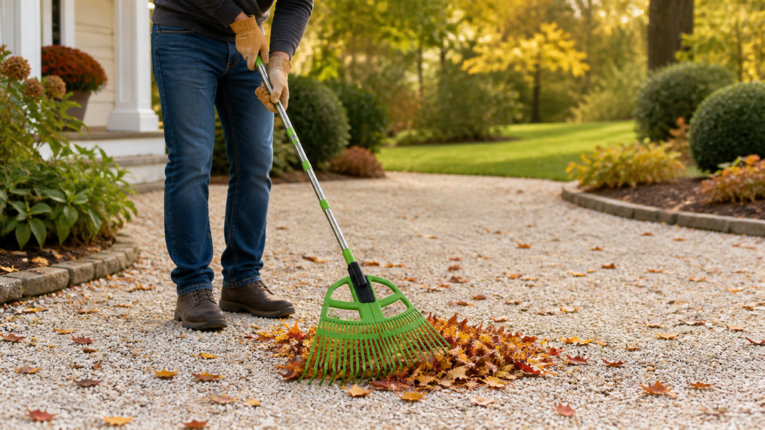 Homeowner raking dry autumn leaves from a gravel path without moving the rocks