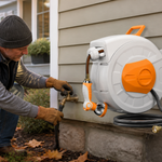 Homeowner winterizing a wall-mounted retractable hose reel before freezing weather